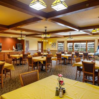 An empty dining room with neatly arranged tables and chairs, ready for guests.