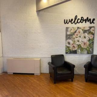 A cozy waiting area featuring comfortable black chairs and a welcoming atmosphere.