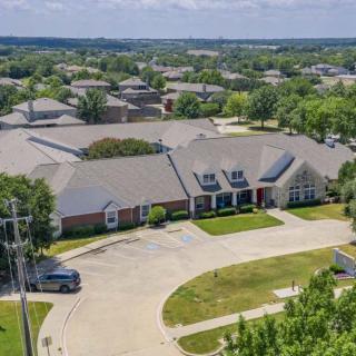 Aerial view of a suburban building with a surrounding residential area and parking lot.