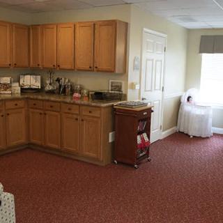 A cozy kitchen corner with wooden cabinets and a carpeted floor.