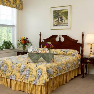 A cozy bedroom with a wooden headboard, floral-patterned bedspread, and matching decor.
