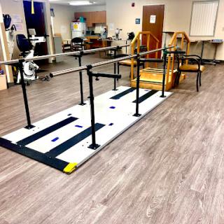 A rehabilitation area featuring a walking pathway with handrails for physical therapy exercises.