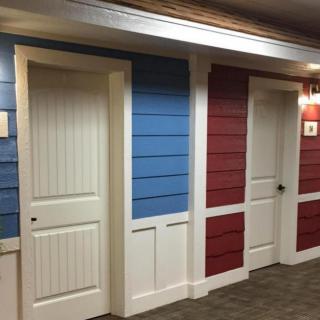 Corridor with blue and red paneled walls and white doors.