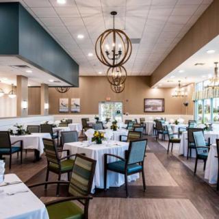 A modern and stylish restaurant interior with neatly arranged tables and elegant chandeliers.
