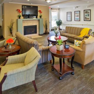 A comfortable and well-decorated living room with sofas, chairs, coffee tables, and a fireplace.