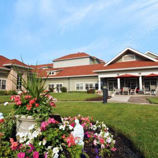 A scenic view of a building with a landscaped garden and colorful flowers.