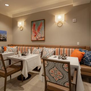 Cozy restaurant interior with elegantly set tables and decorative artwork on the walls.