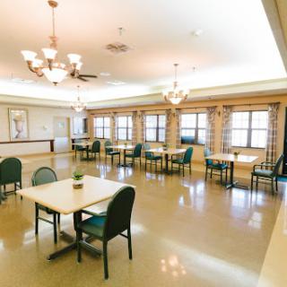 A well-lit and spacious dining area featuring tables and chairs, designed for community gatherings.