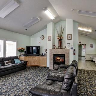 A cozy living room featuring leather sofas, a fireplace, and a TV setup.