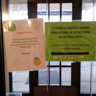 Signs posted on the entrance of a building, providing information to visitors.