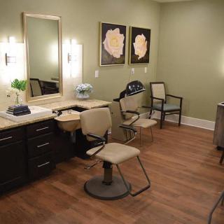 A stylishly furnished hair salon with chairs, mirrors, and wall art.