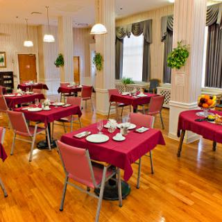A well-arranged dining area featuring tables with red tablecloths, ready for guests.
