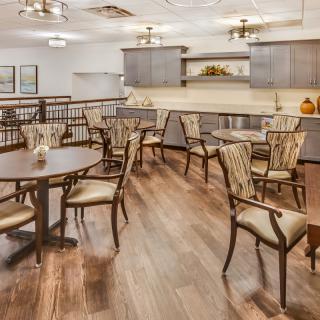A stylish dining area with wooden floors and elegant tables and chairs.
