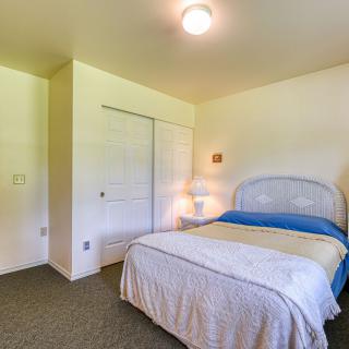 A cozy and minimalist bedroom with a bed, lamp, and closet.