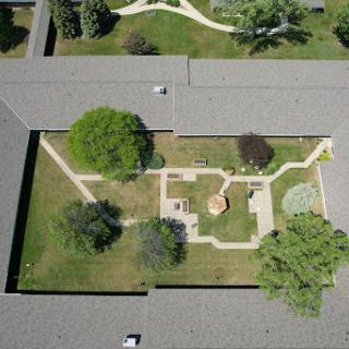 Aerial view of a beautifully landscaped garden with pathways and trees.