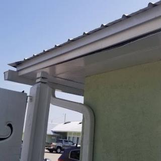 A building's roof with a gutter and downspout system for water drainage.