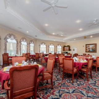 An elegantly decorated dining room with multiple tables and chairs set for a meal.