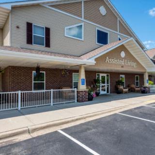 A welcoming entrance to a residential care facility, featuring a well-maintained exterior and accessible parking.