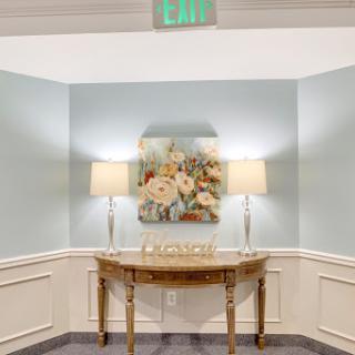 A cozy corner featuring a decorative table with floral artwork and soft lighting.