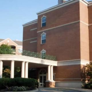 A multi-story brick building with a columned entrance.