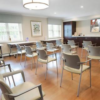 An empty waiting room with arranged chairs and a clean, modern interior.