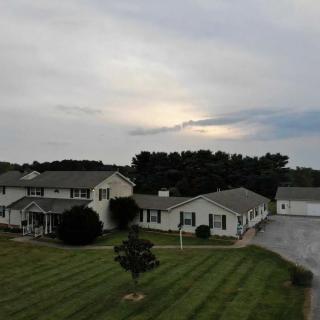 Suburban homes with well-maintained lawns under a cloudy sky.