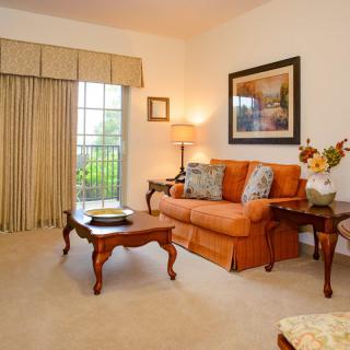 A cozy living room featuring an orange sofa, a wooden coffee table, and classic decor elements.