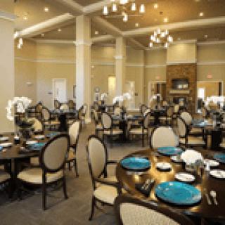 An elegant restaurant dining room with neatly arranged tables and chandeliers.