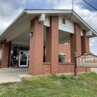A brick building with a welcoming entrance, set against a cloudy sky.