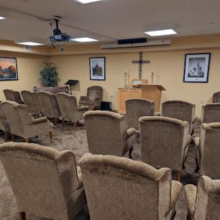 A serene worship area equipped with chairs, a cross, and peaceful decor.