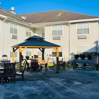 A cozy outdoor patio featuring a gazebo surrounded by seating, perfect for relaxation on a sunny day.