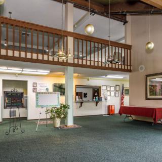 A spacious lobby with a balcony, reception desk, and comfortable seating.