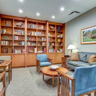 A cozy library corner with wooden bookshelves and comfortable seating.