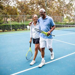 A joyful couple enjoying a day of tennis together on the court.