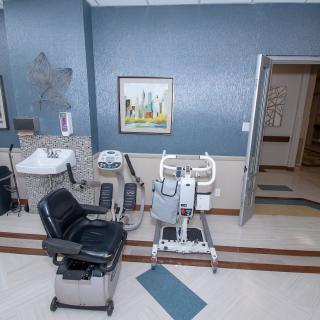 A healthcare clinic room featuring various medical equipment and a chair.