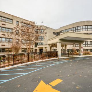 A modern school building featuring a welcoming entrance and a spacious parking area.
