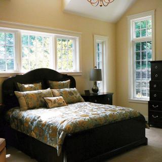A cozy bedroom with elegant furniture and large windows.