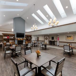 A modern and spacious dining area with skylights and chandeliers.