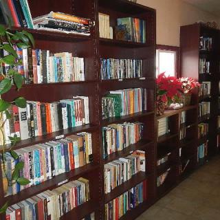 A cozy library room lined with wooden bookshelves filled with books.