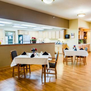 A modern dining area with neatly arranged tables and wooden flooring.