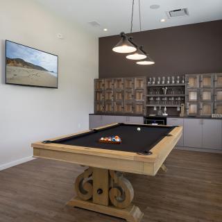 A modern game room featuring a billiards table with ornate wooden legs and contemporary decor.