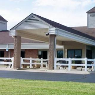 A building entrance with a covered walkway and white fencing.