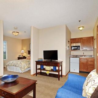 A cozy open-concept apartment featuring a living area, bedroom, and small kitchenette.