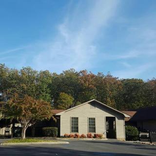 A small building surrounded by trees under a clear blue sky.