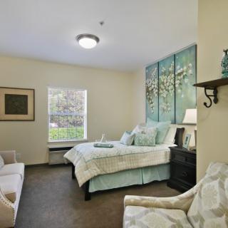 A cozy bedroom with elegant decor and a large window bringing in natural light.