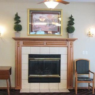 A cozy living room with a fireplace, decorative plants, and elegant wall sconces.