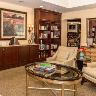 A cozy living room with bookshelves, comfortable chairs, and elegant decor.