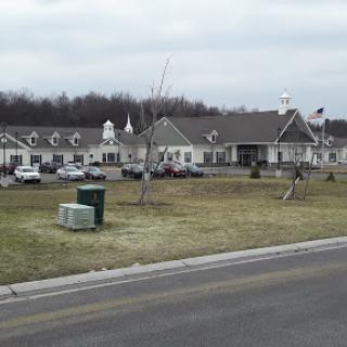 A view of a residential building with landscaped grounds and parked cars.