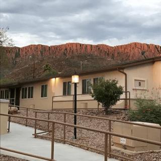 A building set against a backdrop of scenic mountains under a cloudy sky.