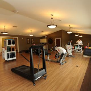 A spacious rehabilitation gym equipped with various exercise machines for physical therapy.